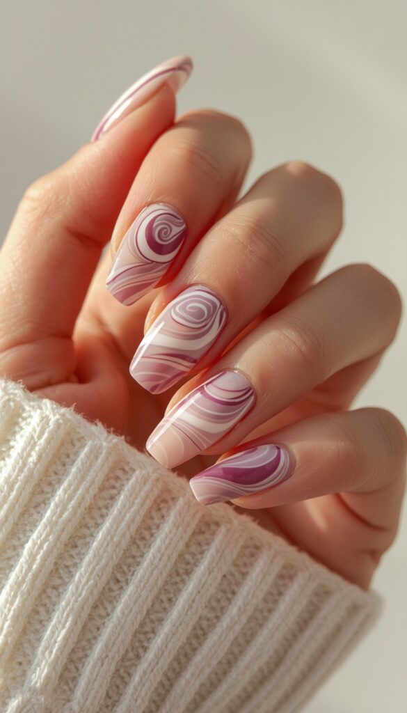 Close-up of press-on nails with abstract swirl designs, glossy finish, soft flowing patterns, and a modern artistic aesthetic