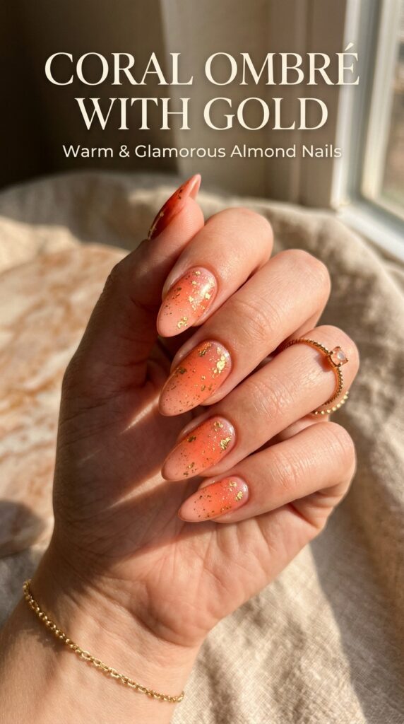 Almond nails with warm coral ombré gradient enhanced with delicate gold flecks for glamorous summer nail design






