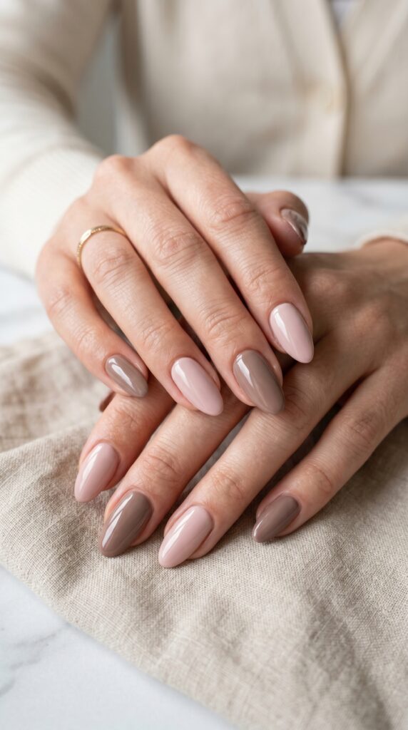 Hands with monochromatic two-tone nail design alternating between light pink and medium rose or pale gray and deeper taupe across fingers for sophisticated tonal minimalist summer manicure






