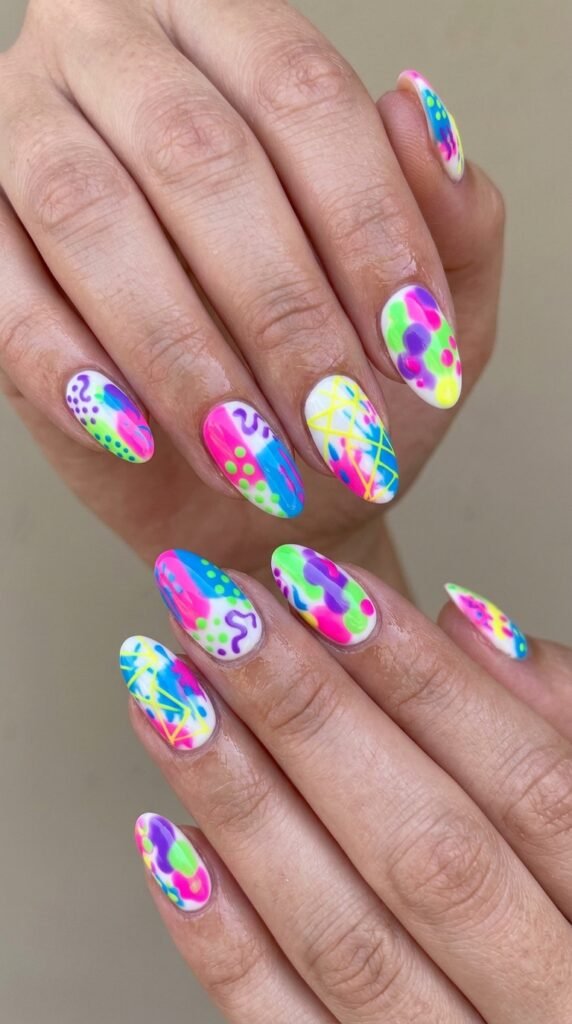 Hands with multi-neon abstract nail art combining pink, blue, green, yellow, and purple in free-form dots, lines, and geometric patterns for creative bold artistic summer manicure







