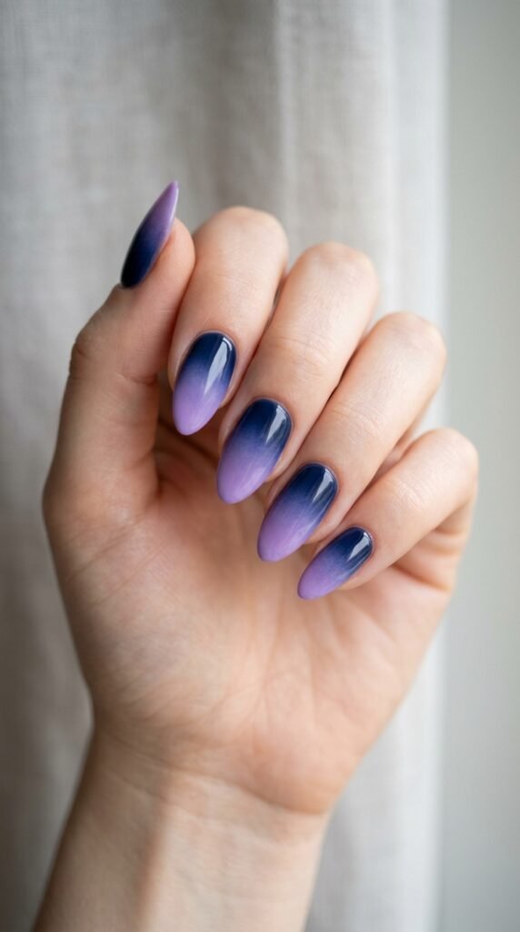 Navy blue to lavender fade nails with a smooth gradient blend and glossy finish, creating a cool-toned, elegant, and modern ombre manicure look