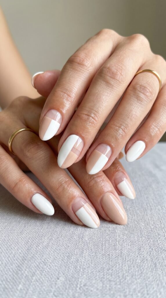 Hands with negative space color block nail design featuring geometric divisions of polished sections and bare nail areas in two colors for sophisticated architectural minimalist summer manicure






