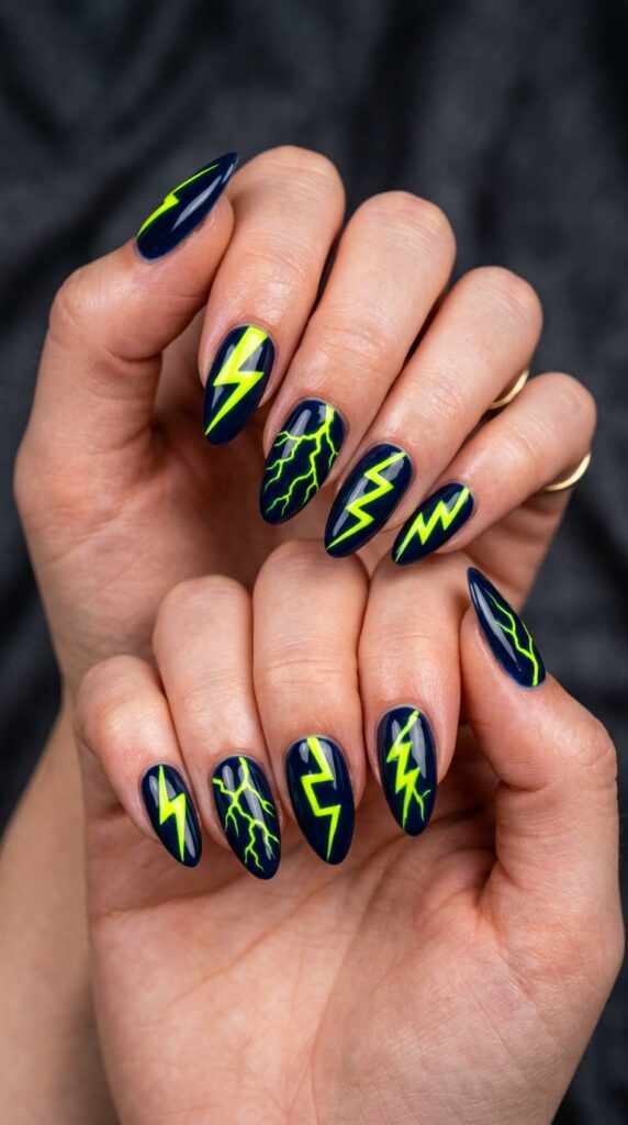 Hands with neon yellow lightning bolt designs on dark navy or black base nail polish creating dramatic high-contrast graphic effect for bold edgy summer manicure






