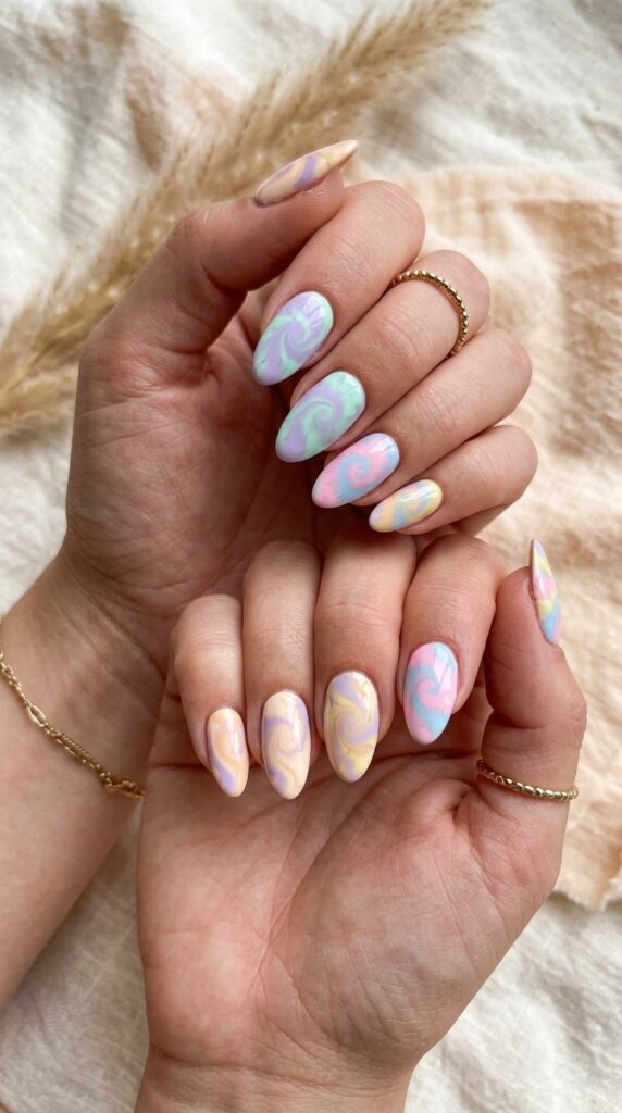 Vibrant and playfully bohemian pastel tie-dye and swirl pattern nails featuring multiple soft pastel colors swirled organically together—pink with blue, lavender with peach, mint with yellow—creating unpredictable tie-dye effects, dynamic color interactions, contemporary bohemian aesthetic, and artistic creative expression.





