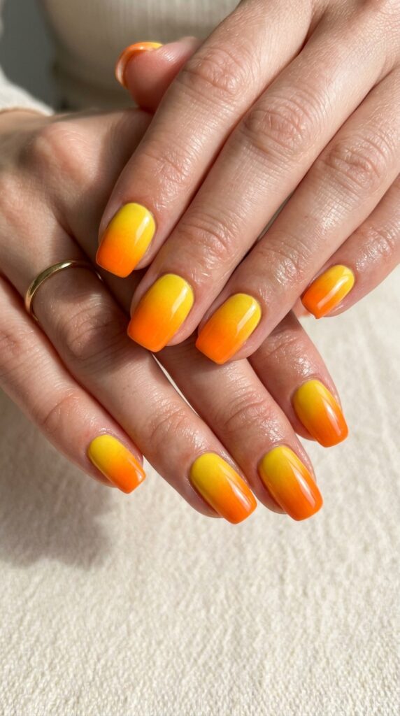 Yellow sunshine to orange burst ombre gradient nails with vibrant transition from bright yellow base to warm orange tips for bold summer nail art.