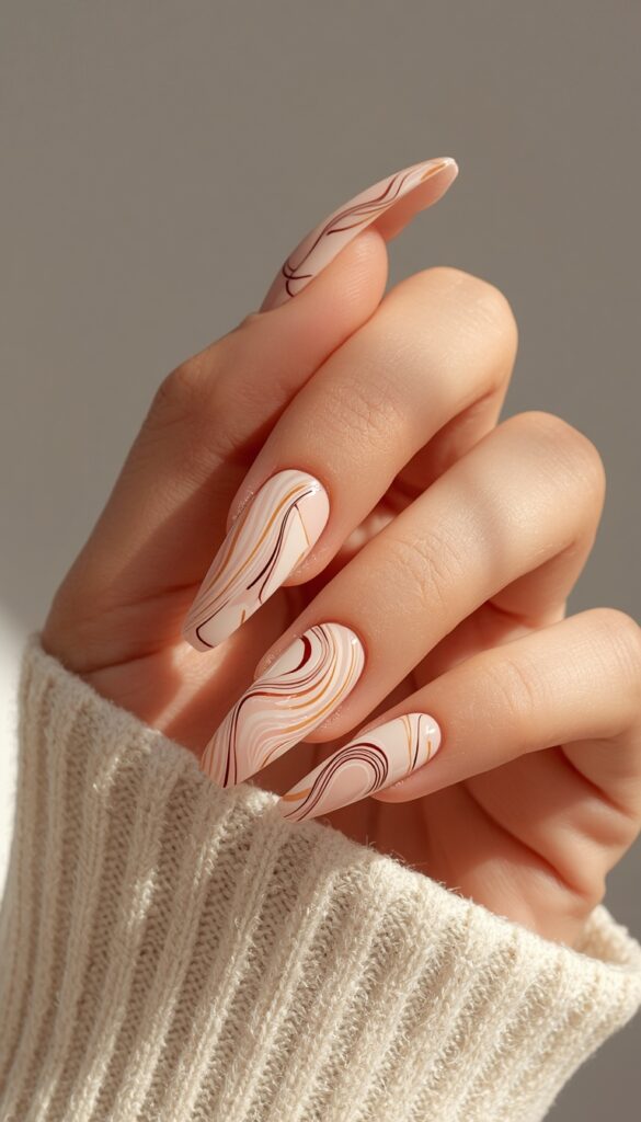 Close-up of acrylic nails with abstract swirl designs, glossy finish, flowing patterns, and a modern artistic aesthetic