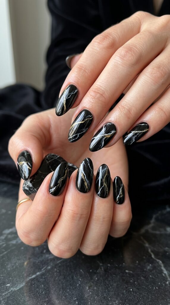 Black marble statement nails with bold veining and glossy finish, creating a dramatic, luxurious, and high-fashion manicure with a modern edgy aesthetic