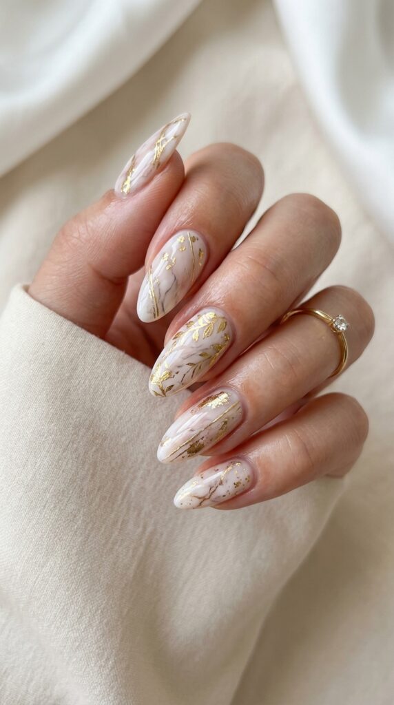 Gold accent marble nails with soft veining and metallic details, creating a luxurious, elegant, and modern manicure with a refined aesthetic