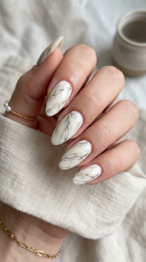 Classic white marble nails with delicate veining and glossy finish, creating a luxurious, elegant, and timeless manicure inspired by natural stone