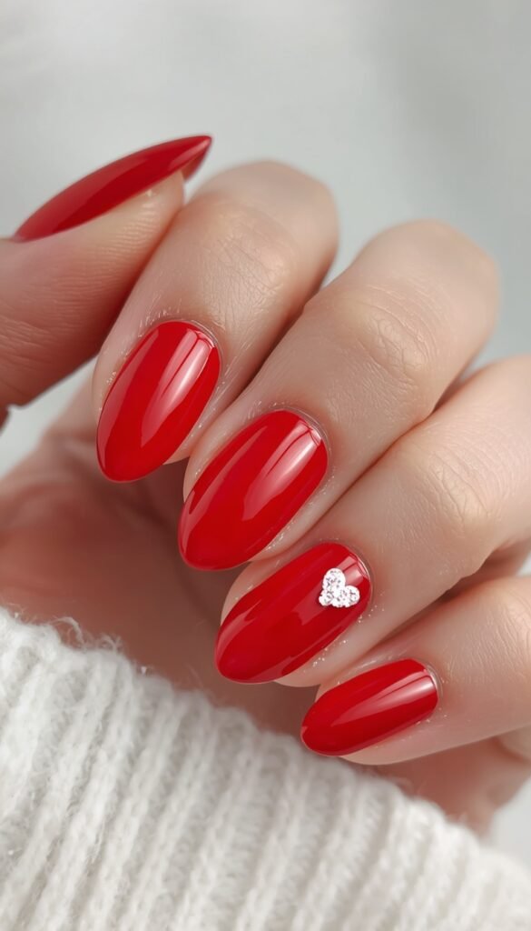 Classic red nails with small heart accents, creating a romantic, elegant, and stylish manicure perfect for a chic and feminine look